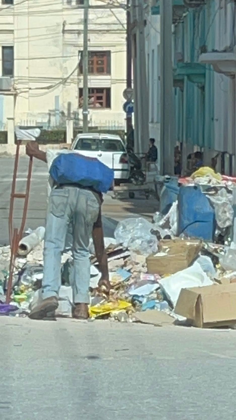 Man searching through trash on the street in Cuba