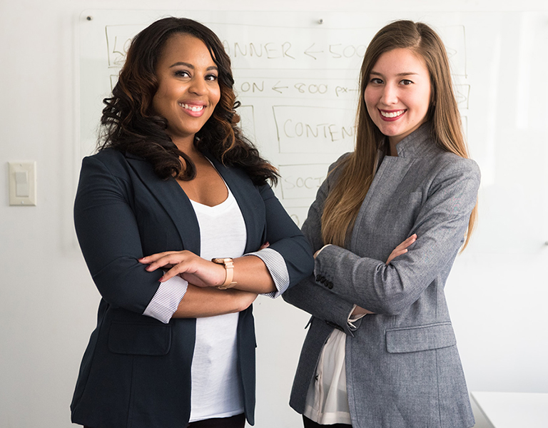 Two women standing with arms crossed