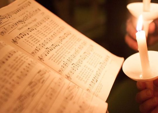 Candles illuminating a hymnal