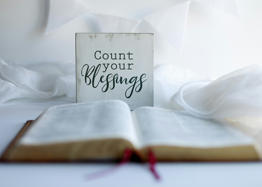 Bible open with a sign that says count your blessings