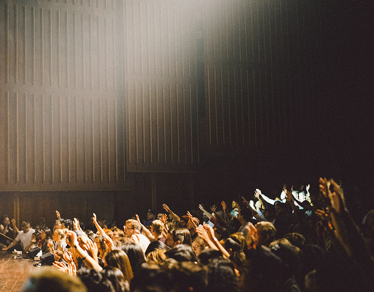 people worshiping in an auditorium 